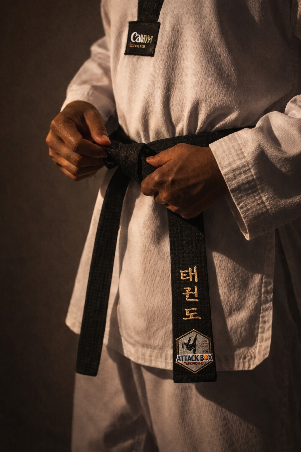Close-up of a taekwondo black belt being tied